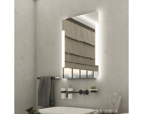 Koupelna s osvětleným zrcadlem, umyvadlem a doplňky