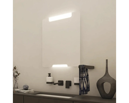 Koupelna s osvětleným zrcadlem, umyvadlem a doplňky pro moderní atmosféru