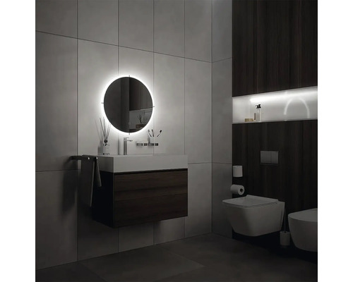 Moderní koupelna s osvětleným zrcadlem, umyvadlem a toaletou.