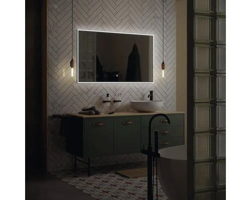 Moderní koupelna s osvětleným zrcadlem, umyvadlem a volně stojící vanou.