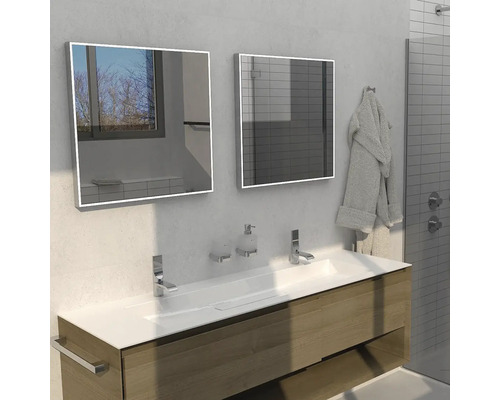 Koupelna s umyvadlem, dvěma zrcadly, bateriemi a ručníkem