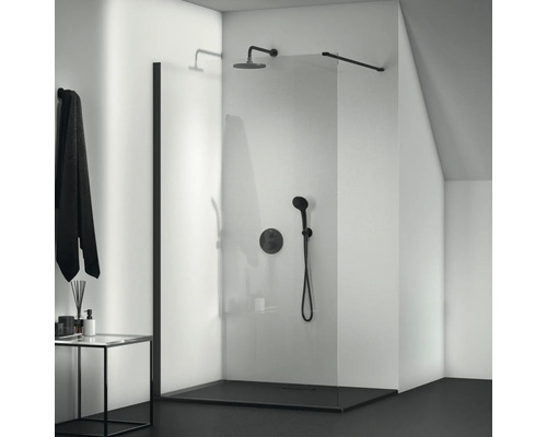Sprchový kout v úrovni podlahy se skleněnou stěnou a černými armaturami v koupelně.