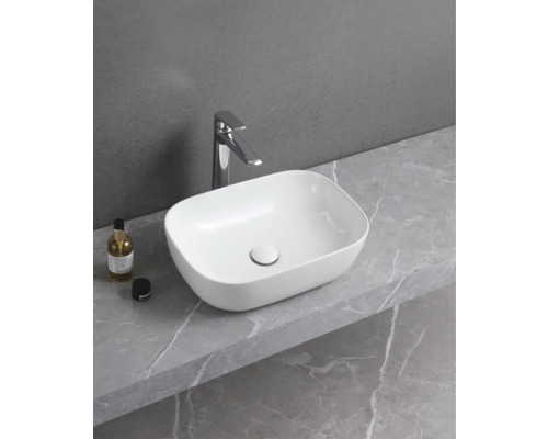 Keramické umyvadlo na desce s vodovodní baterií