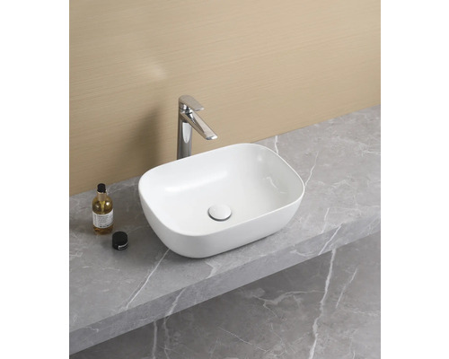 Keramické umyvadlo na desce s vodovodní baterií