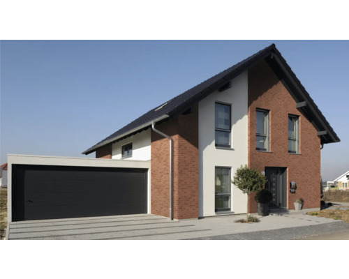 Moderní rodinný dům s garáží a dlážděnou příjezdovou cestou.