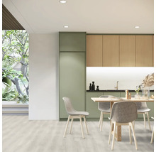 Světlá kuchyně s jídelním stolem a židlemi, kombinovaná s kuchyňským nábytkem v dřevěném vzhledu a zelené barvě.