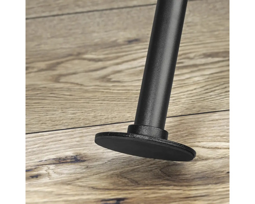 Detailní pohled na kovovou nohu nábytku s ochranou podlahy na dřevěné podlaze.