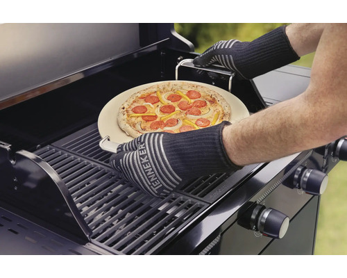 Pizza na pizza kameni je umístěna na plynový gril