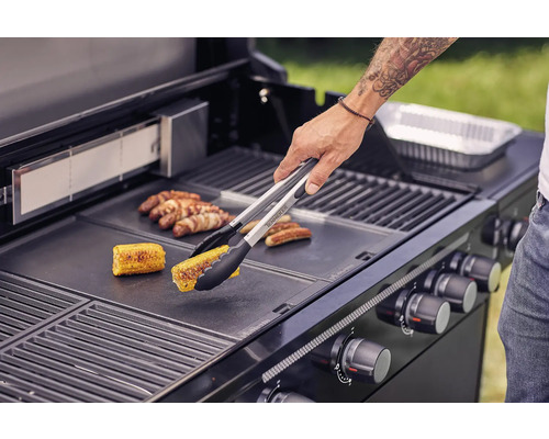 Osoba griluje kukuřici a klobásy na grilu.