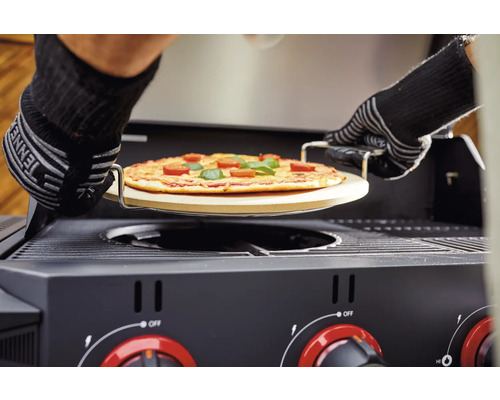 Pizza na pizza kameni se zasouvá do plynového grilu