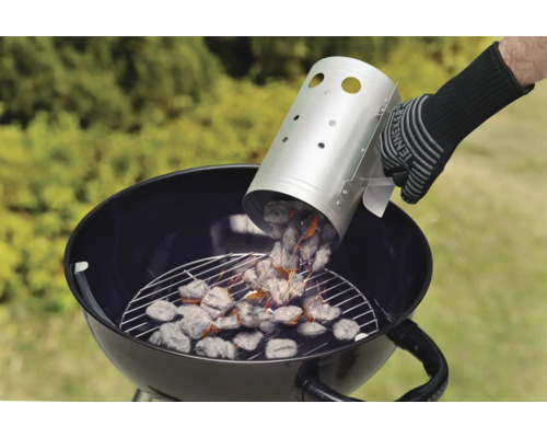 Osoba sype dřevěné uhlí z komínu na podpalování do grilu na dřevěné uhlí.