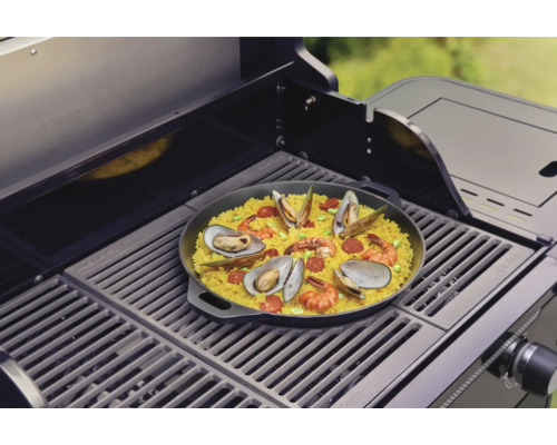 Paella s mořskými plody připravená na grilu.