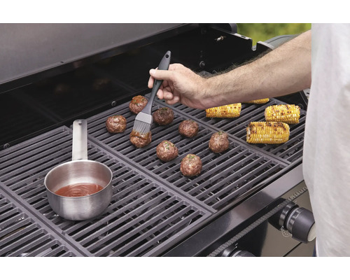 Na grilu se připravují masové kuličky a kukuřičné klasy.