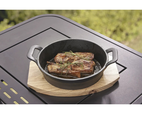 Grilované maso s rozmarýnem v černé litinové pánvi na dřevěném stole