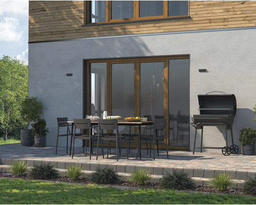 Venkovní posezení se zahradním stolem, židlemi a grilem na dlážděné terase