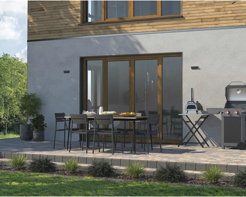 Terasa s jídelním stolem, židlemi, grilem a pecí na pizzu před domem