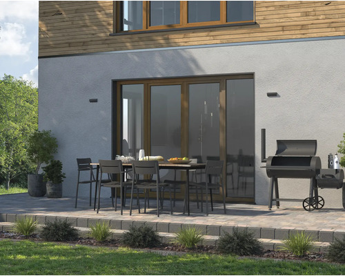 Venkovní prostor s terasou, zahradním stolem, židlemi a grilem pro chvíle odpočinku venku.