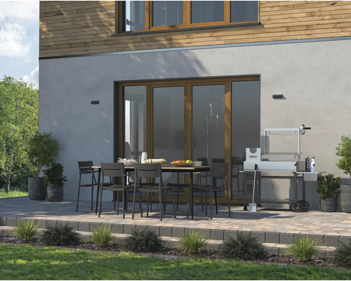 Venkovní prostor s jídelním stolem, židlemi a grilem před domem