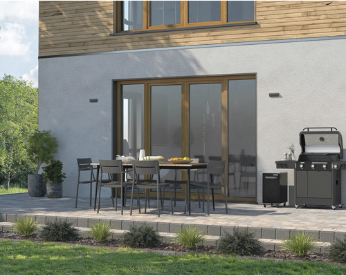 Terasa s plynovým grilem, zahradním stolem a židlemi před domem