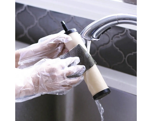 Vodní filtr se čistí pod vodovodním kohoutkem pomocí čisticí podložky.