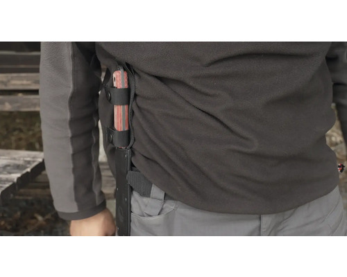 Osoba s velkým nožem s pevnou čepelí v pochvě připevněné k boku