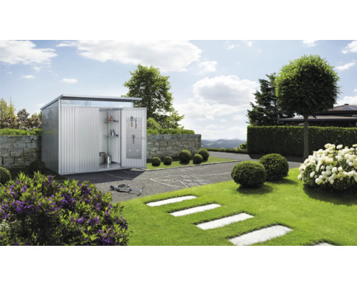 Zahradní scéna s kovovou kůlnou na nářadí, která je napůl otevřená a uvnitř dveří jsou police a háčky