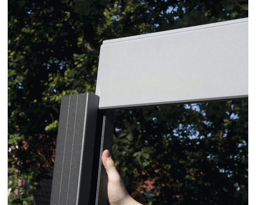 Detail terasové střechy s hliníkovým rámem a osobou dotýkající se rámu.