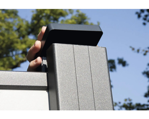 Ruka umisťuje kryt na sloupek plotu