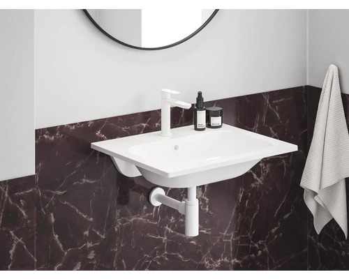 Umyvadlo s baterií, sifonem a ručníkem v koupelně