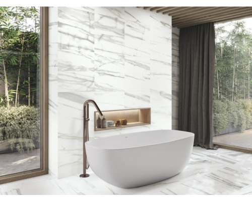 Moderní koupelna s volně stojící vanou, baterií a mramorovými obklady.