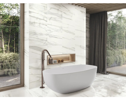 Koupelna s vanou, baterií a obkladem stěn s mramorovým vzhledem