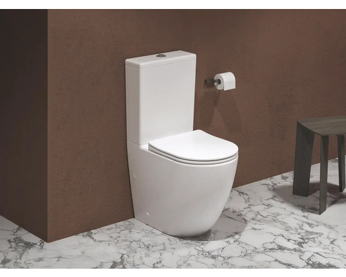 Bílá stojící toaleta před zdí