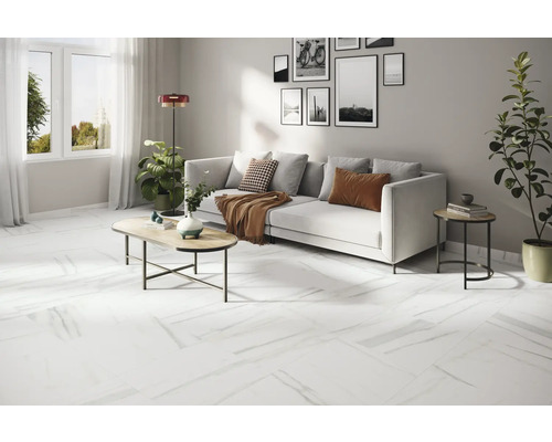 Světlý obývací pokoj s bílou pohovkou, konferenčním stolkem a bílou podlahou s mramorovým vzhledem.