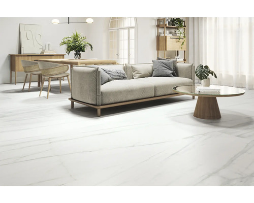 Obývací pokoj s pohovkou, stolem a podlahovými dlaždicemi s mramorovým vzhledem.