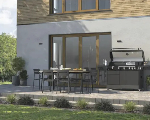 Terasa se zahradním stolem, židlemi a grilem před fasádou domu