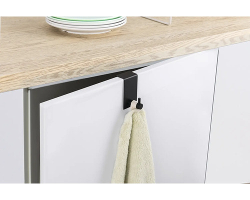 Černý dveřní hák s ručníkem na kuchyňských dveřích