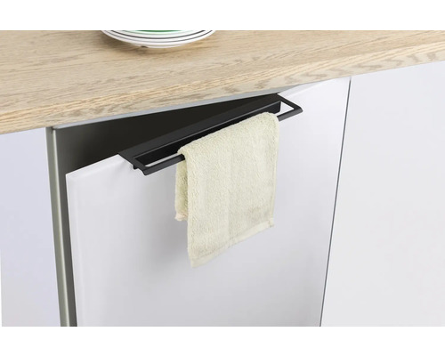 Černý držák na ručníky visí na dveřích kuchyňské skříňky s ručníkem.