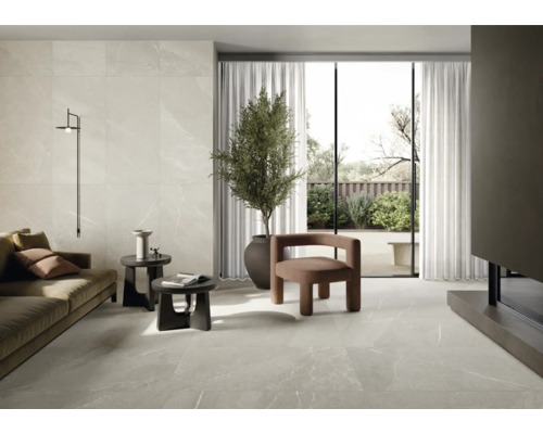 Světlý obývací pokoj s dlažbou, pohovkou, křeslem, pokojovou rostlinou a denním světlem.