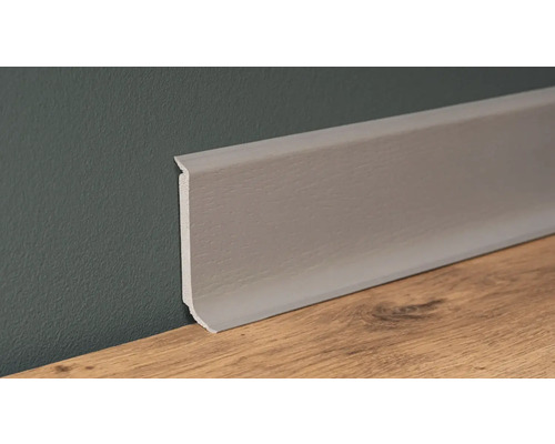 Plastová podlahová lišta na zdi a dřevěné podlaze