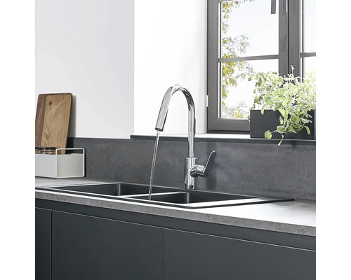 Kuchyňský dřez s vodovodní baterií a kuchyňskými potřebami