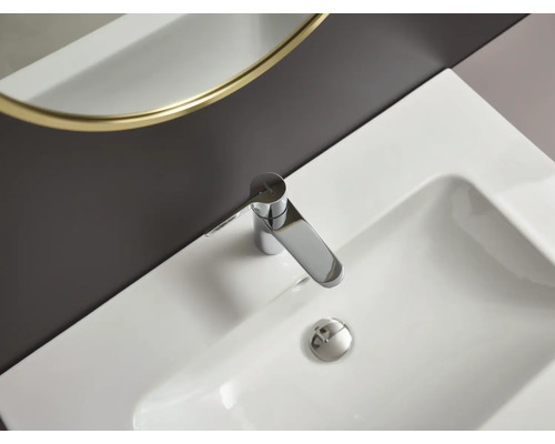 Fotografie bílého umyvadla s chromovou vodovodní baterií.