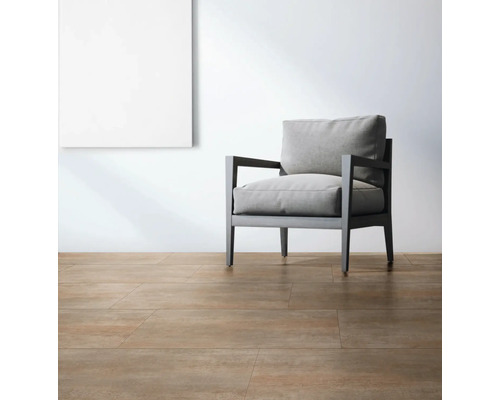 Světlá místnost s podlahovými dlaždicemi, křeslem a obrazem na stěně