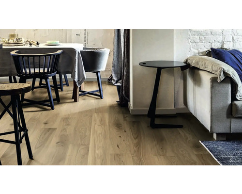 Obytný prostor se světlou dřevěnou podlahou, jídelním stolem a pohovkou