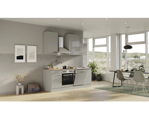 Světlá kuchyně s vestavěnými spotřebiči a jídelním koutem u velkých oken