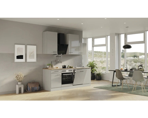 Světlý obývací prostor s kuchyňskou linkou, jídelním stolem a židlemi.