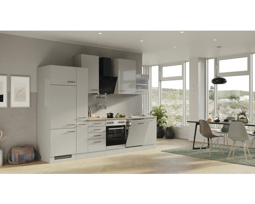 Světlá kuchyně s kuchyňskými skříňkami, digestoří, dřezem, myčkou, troubou a jídelním prostorem ve světlé místnosti