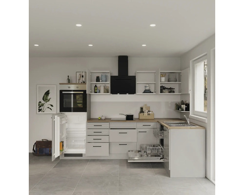 Světlá kuchyně s otevřenou lednicí, myčkou, varnou deskou, digestoří a horními skříňkami.