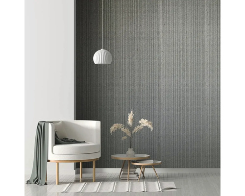 Obývací pokoj s křeslem, odkládacími stolky a závěsným svítidlem před vzorovanou stěnou