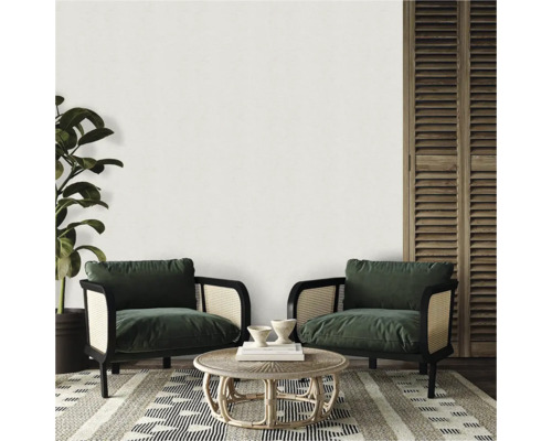 Světlý a útulný obývací kout se dvěma křesly, kulatým stolem a vzorovaným kobercem