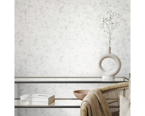 Obývací pokoj s tapetou se vzorem, regálem a dekorativními prvky.